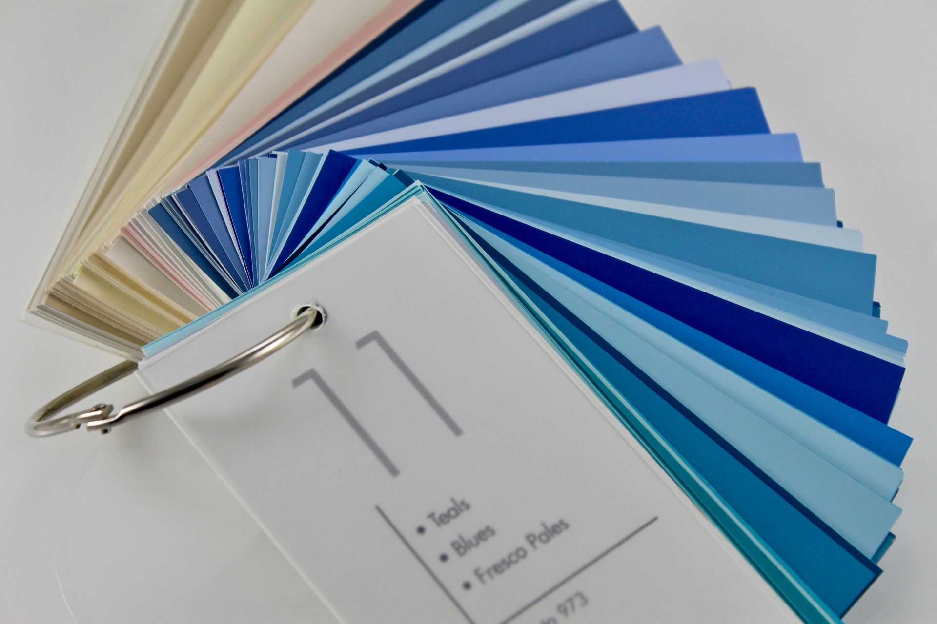 Fan of blue and neutral paint color swatches on a ring-bound sample book