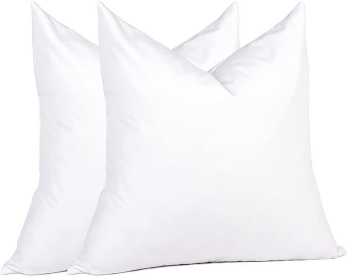 Three white pillows stacked together on a plain background