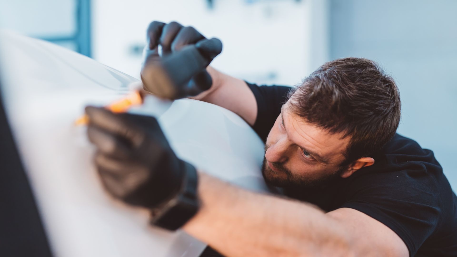 Auto Dent Removal Services being done by an expert car mechanic who is applying a tool to a car