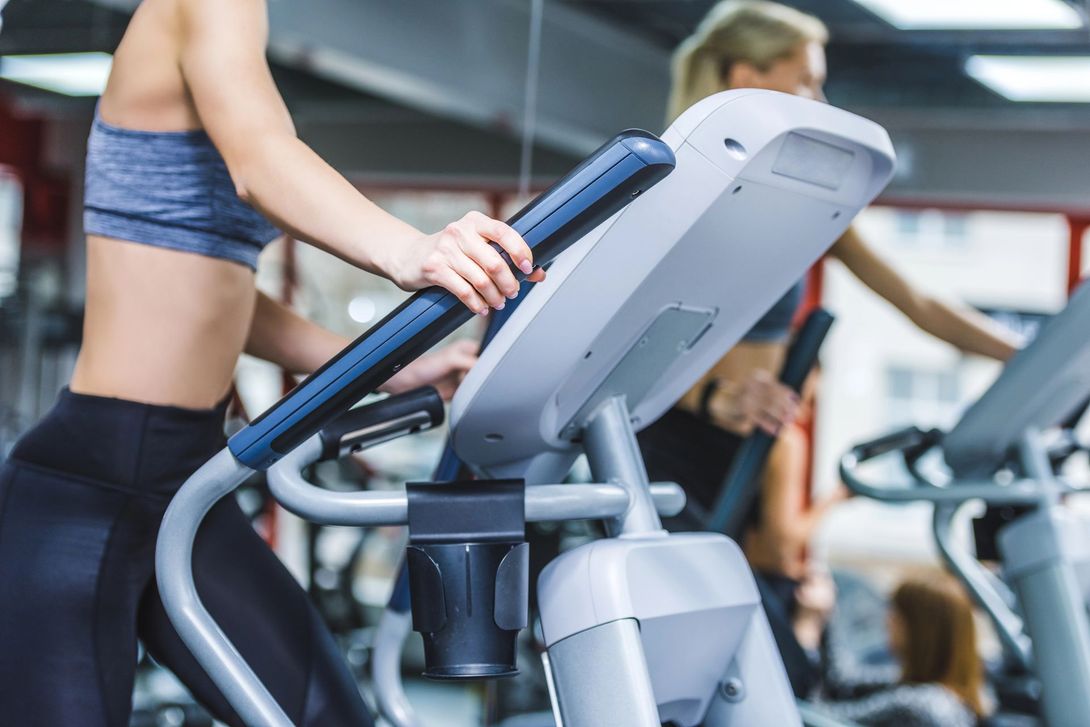 Persona che utilizza un tapis roulant in palestra, con un primo piano della console e del manubrio.