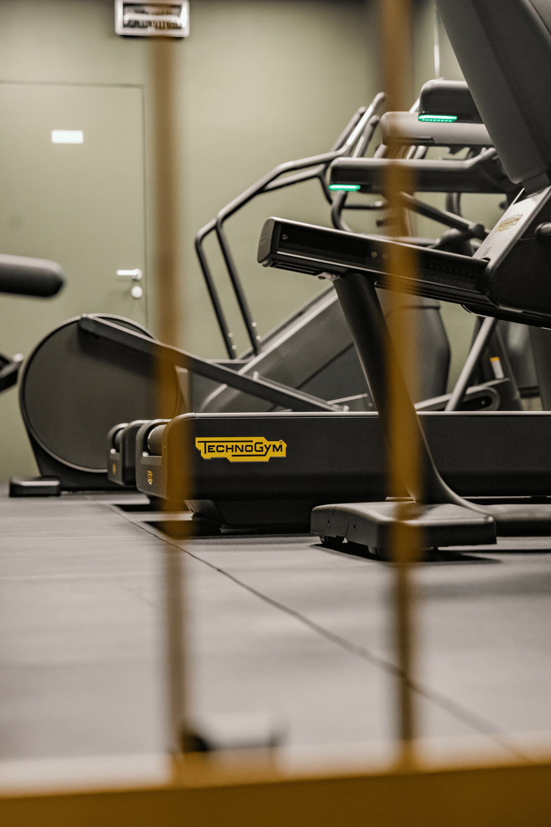 Persona che utilizza un tapis roulant in palestra, con un primo piano della console e del manubrio.