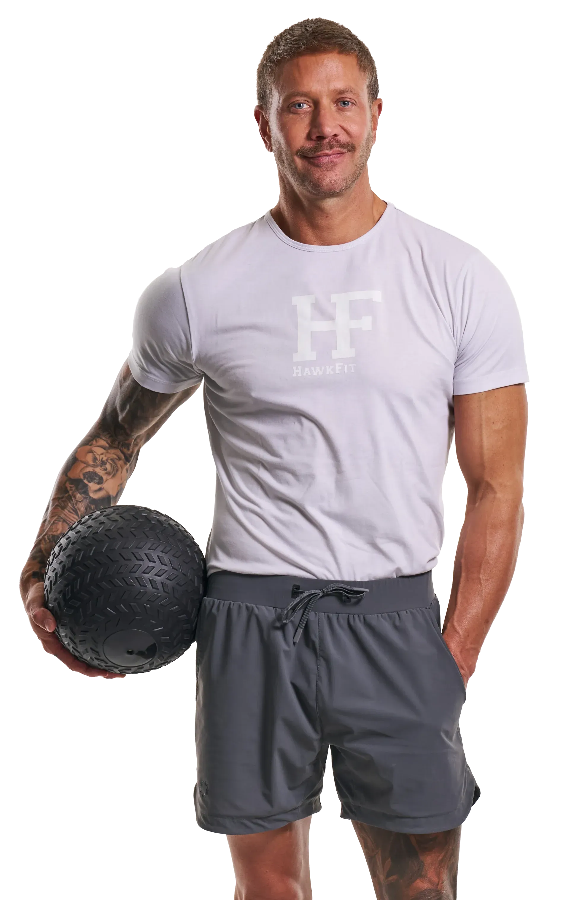 Man in gray workout clothes holding a black medicine ball against a white background