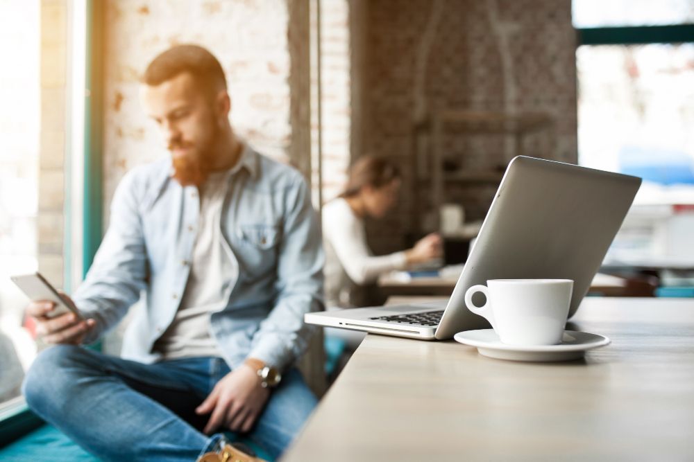 homem tentando melhorar o sinal wifi do seu escritório
