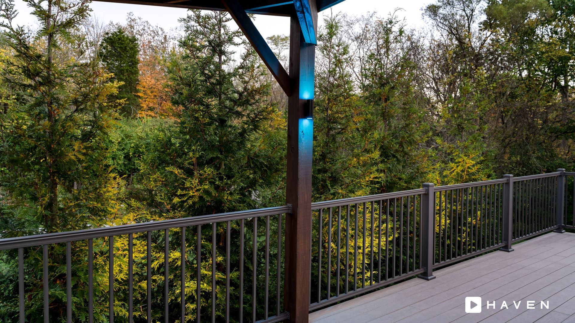 A deck with a gazebo and trees in the background.