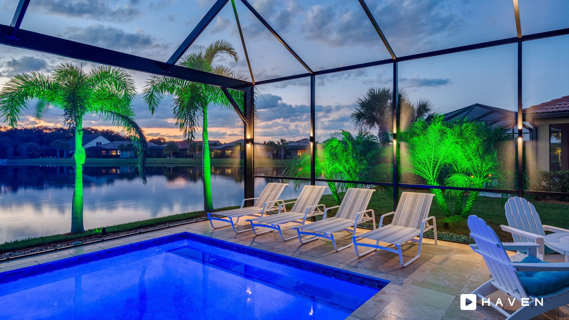 A swimming pool with chairs around it and a view of a lake.
