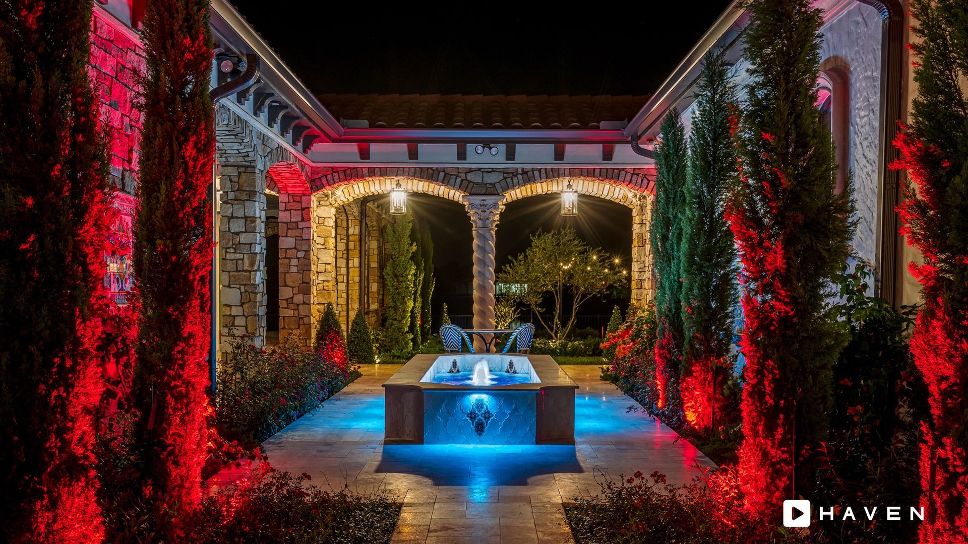 There is a fountain in the middle of the courtyard surrounded by trees.