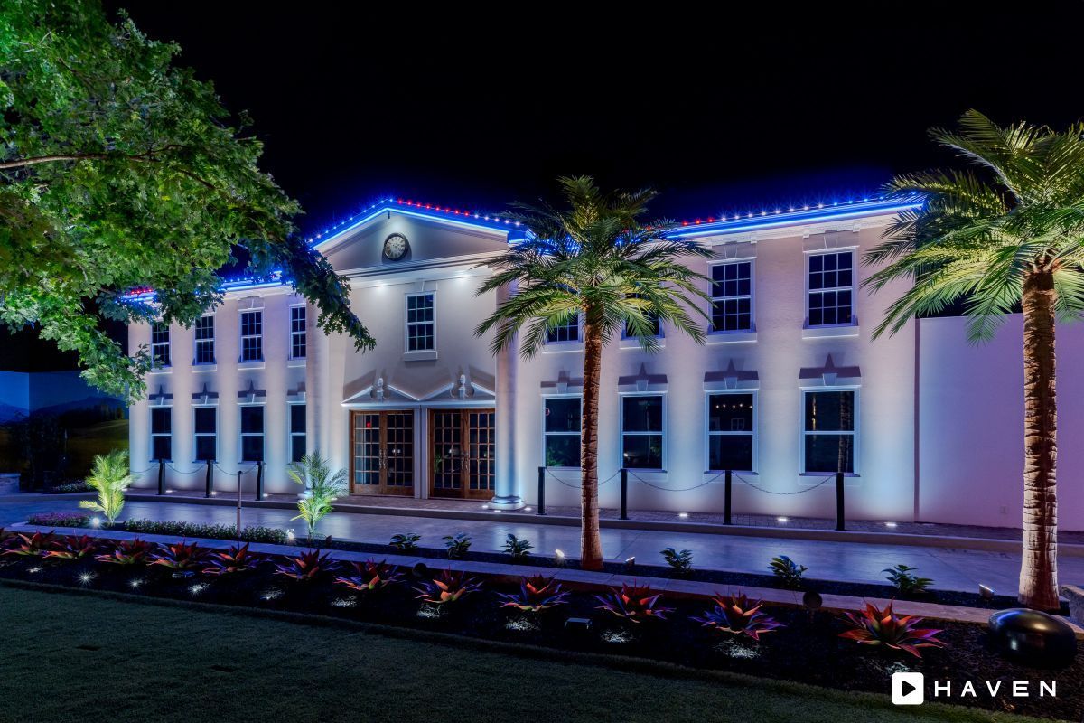A large white building with palm trees in front of it