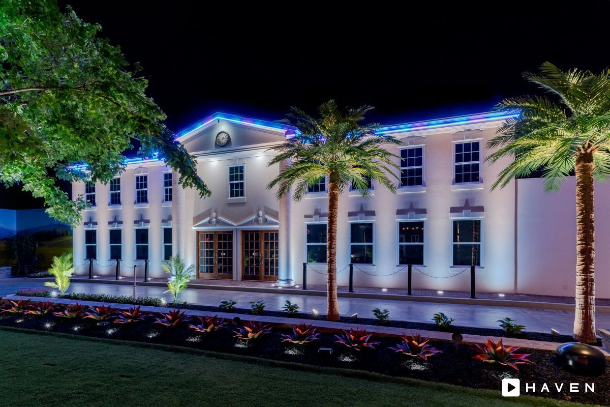 A large white building with palm trees in front of it