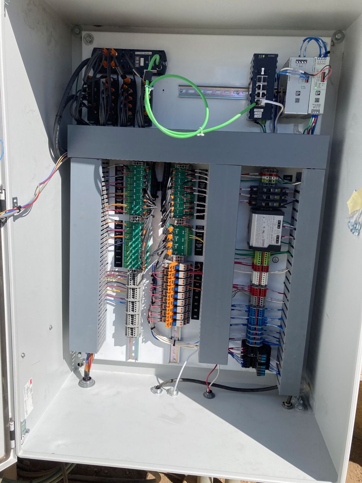Electrical control panel with wires and components inside a gray metal box.