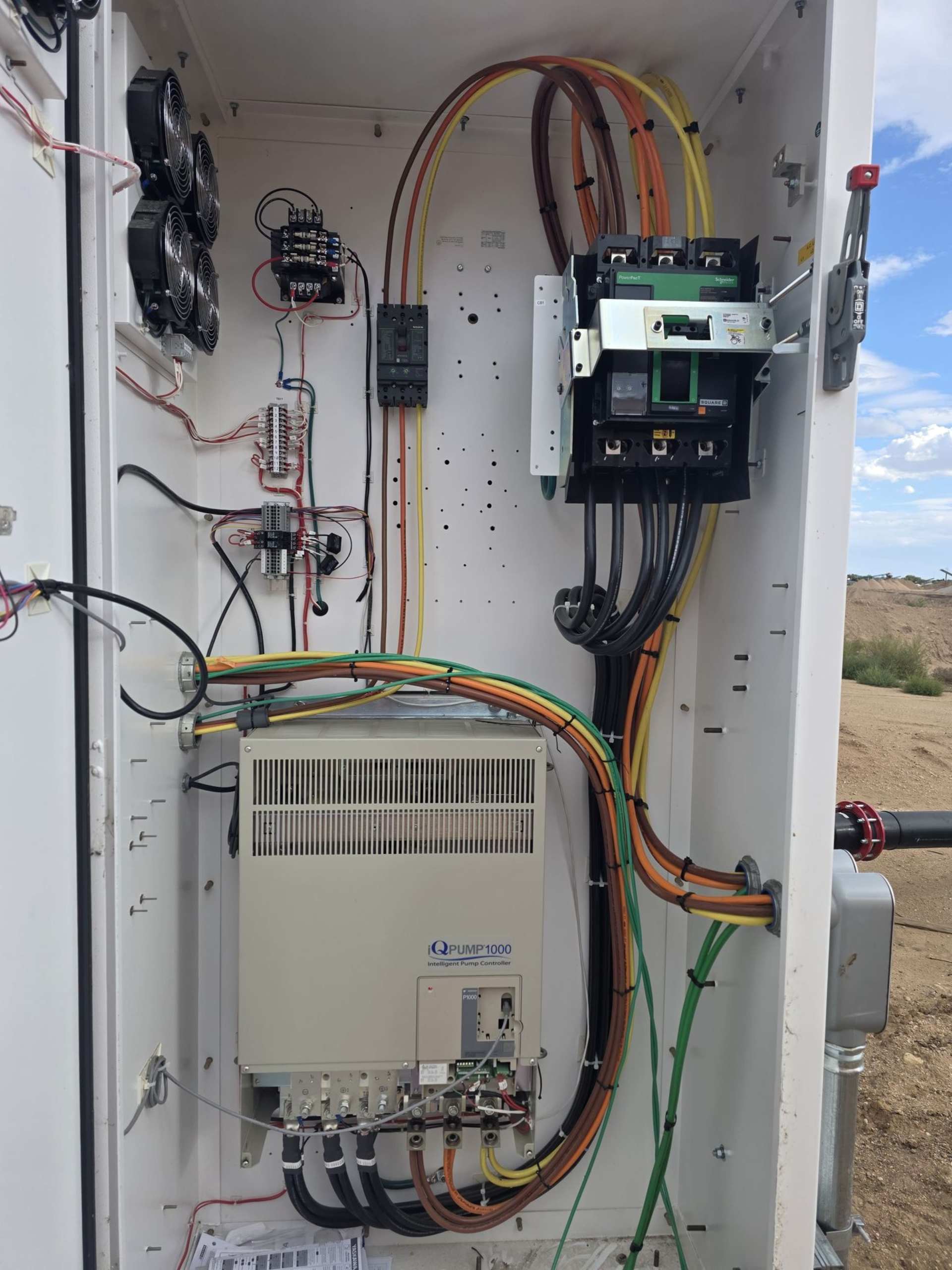 White electrical cabinet with wires and components. Contains a motor controller and other electrical parts.