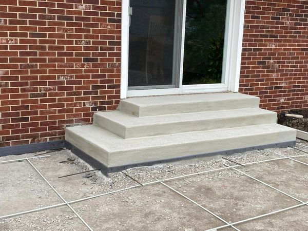 A brick house with concrete steps and a sliding glass door