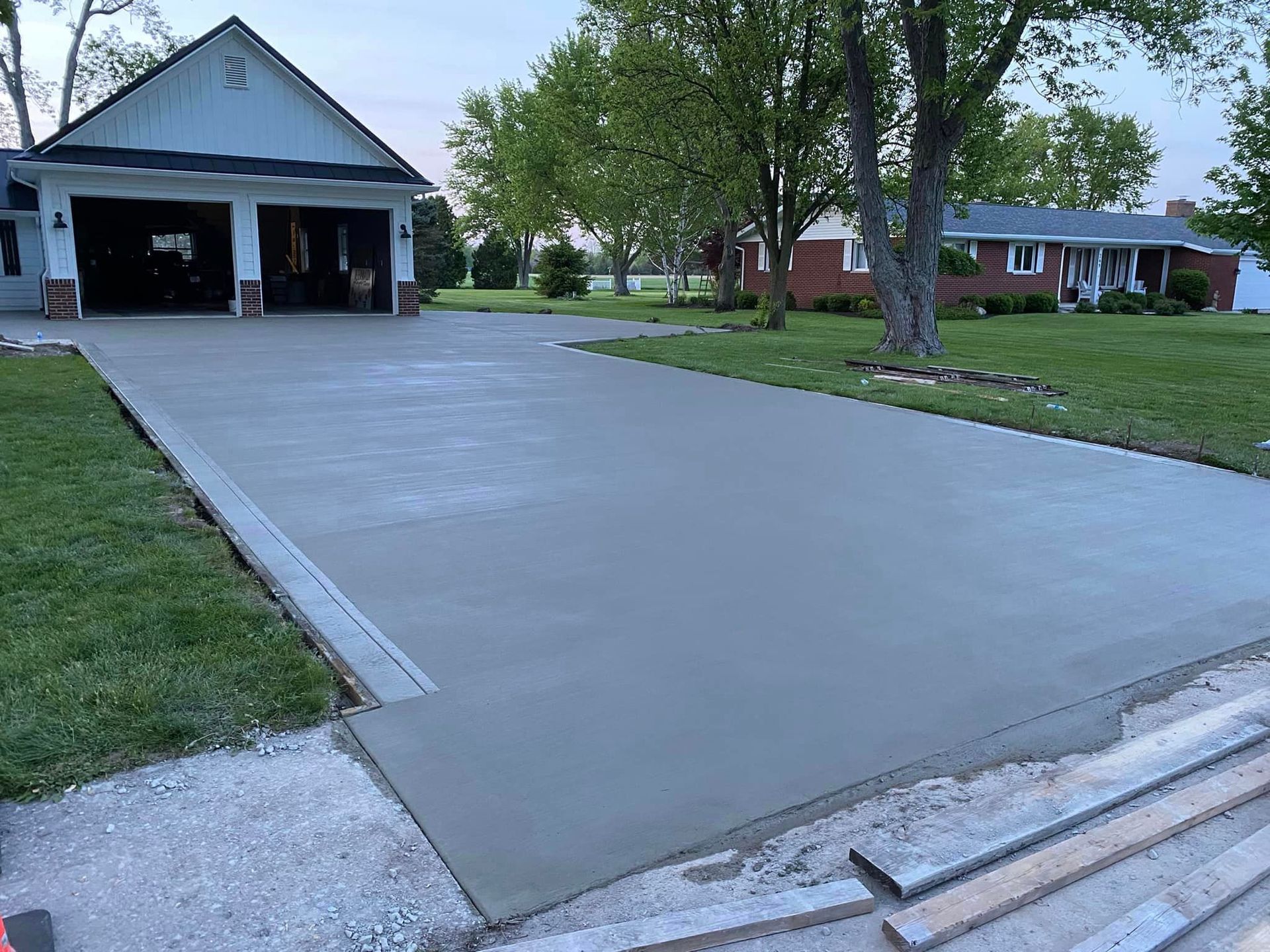 A concrete driveway is being built in front of a house.