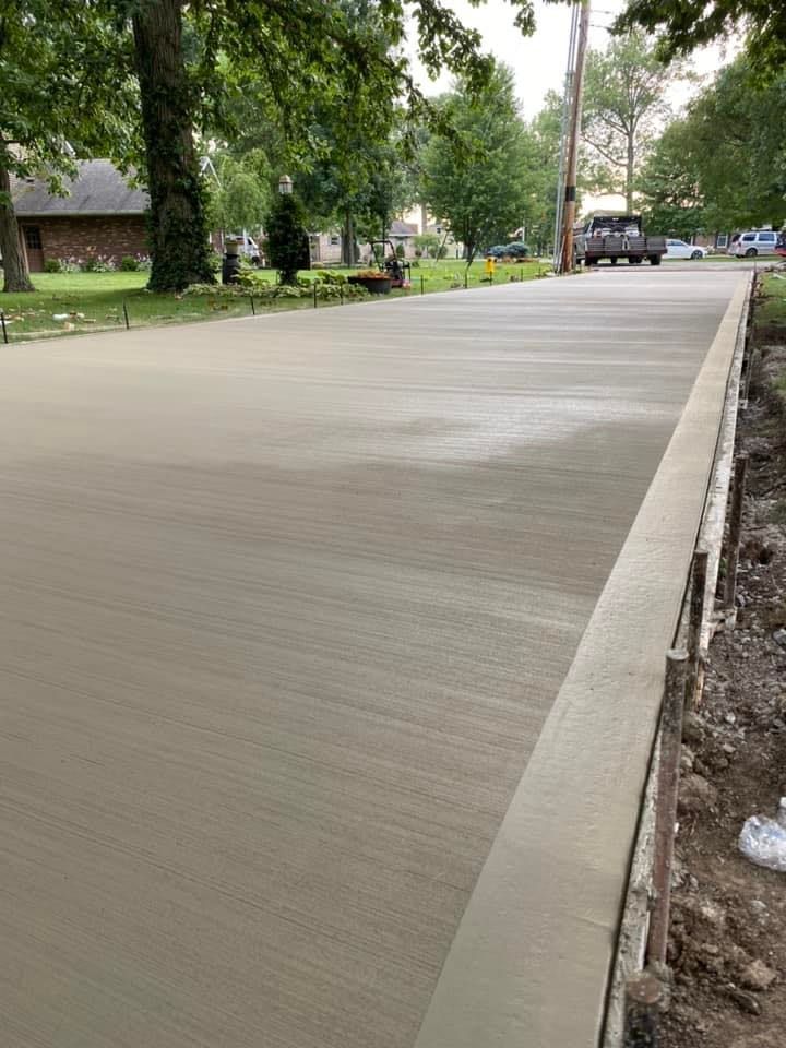 A concrete driveway is being built on the side of a road.