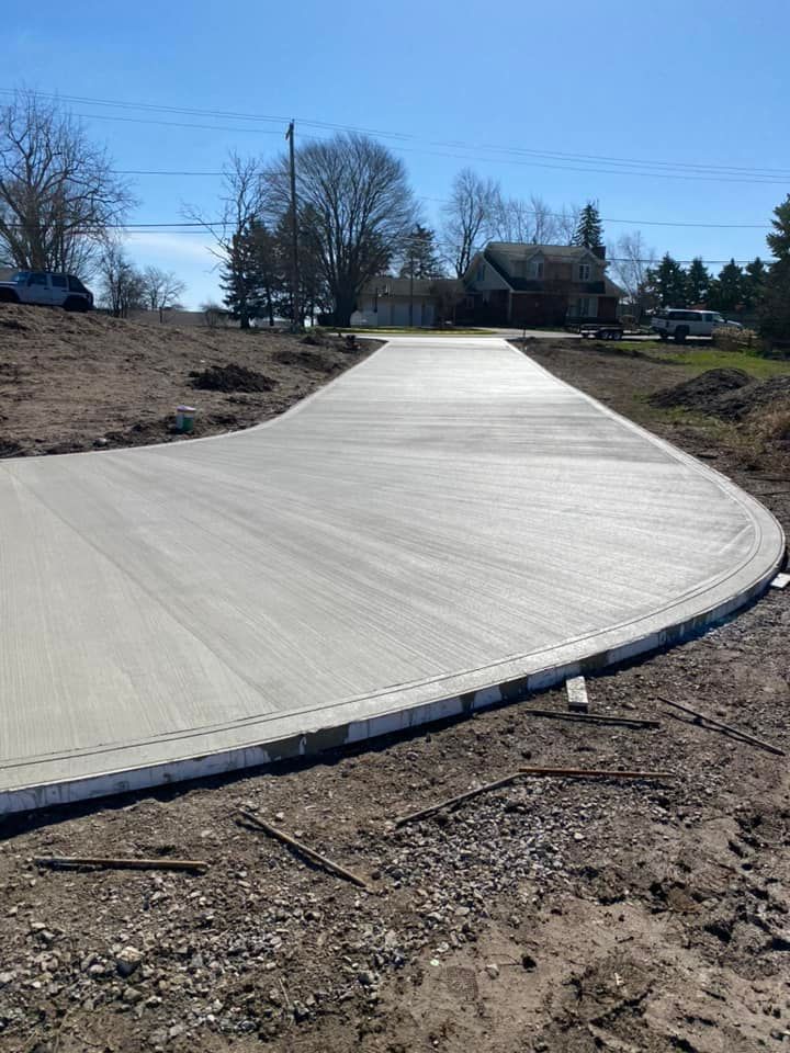 A concrete driveway is being built in the middle of a dirt field.