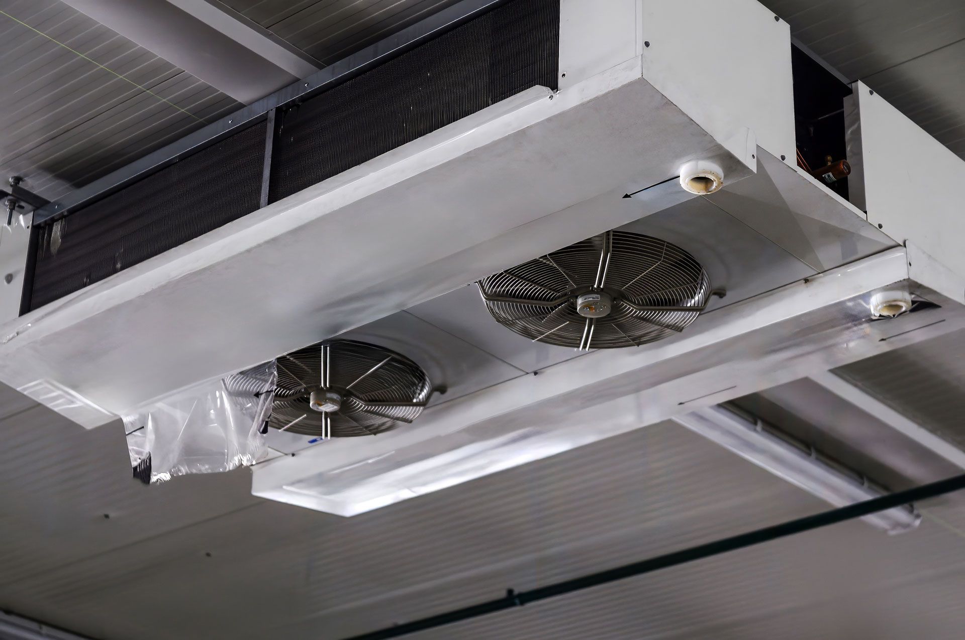 Two ceiling-mounted industrial air conditioning units with fans.