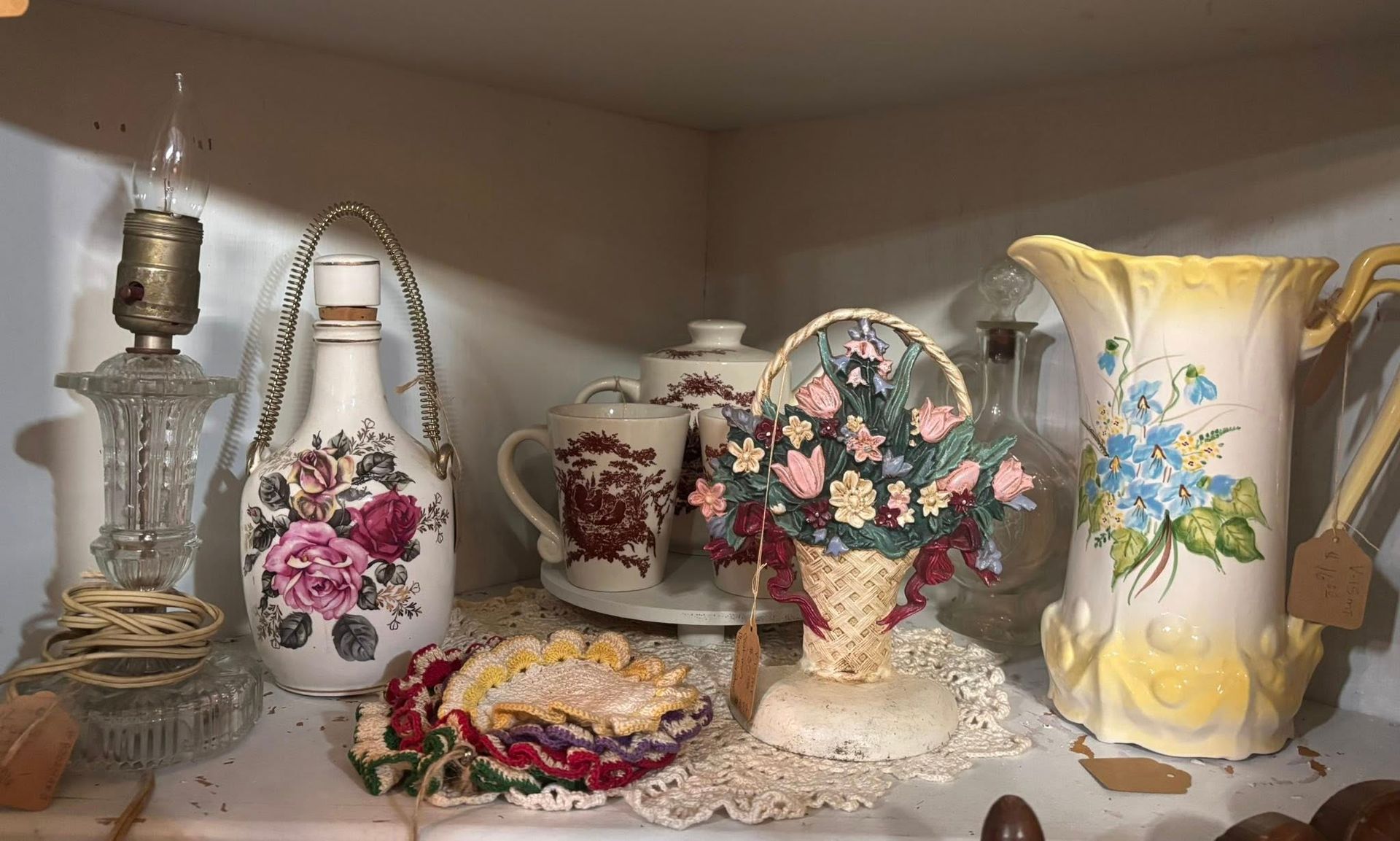  antique lamp, floral pitcher, basket of flowers, teacups and other vintage decor.