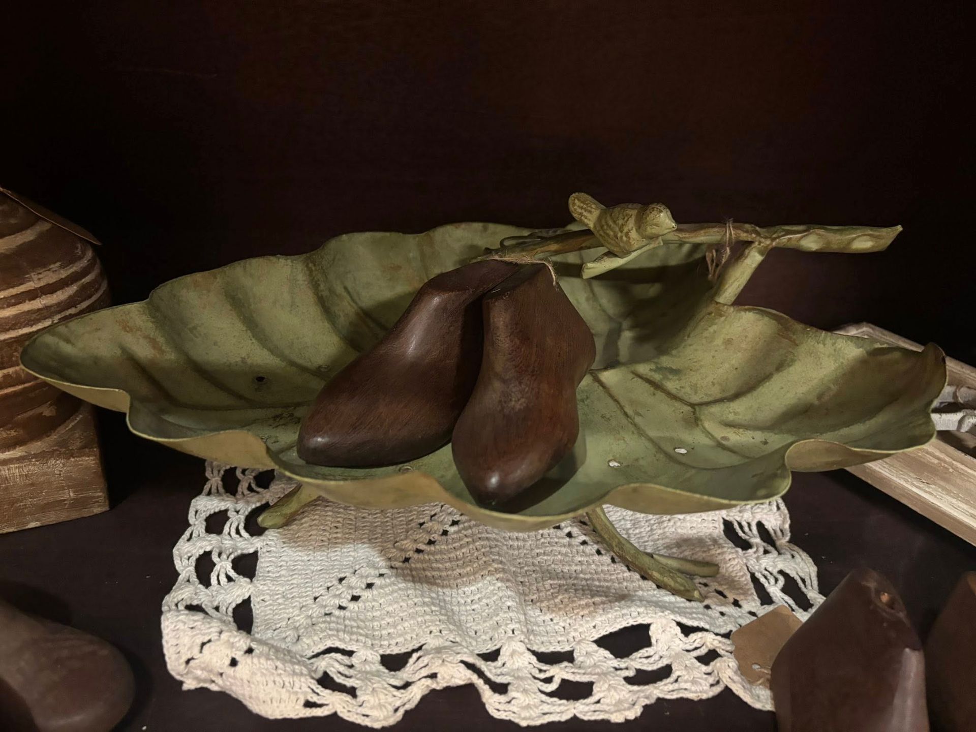 Brown shoes in leaf-shaped dish on lace doily
