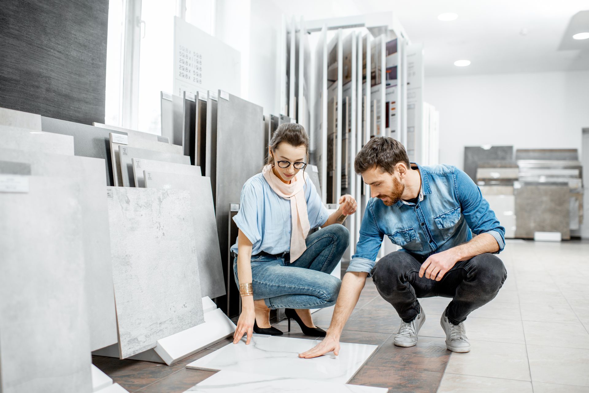 A couple is looking at some tiles in a store. A couple is looking at some tiles in a store.