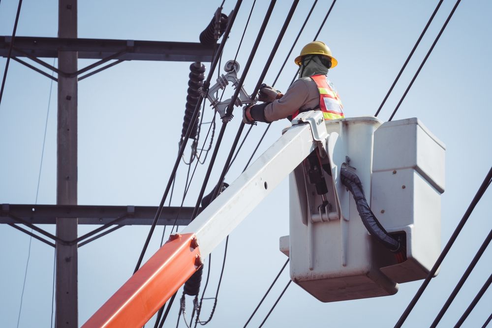 Lineman Working on Power Lines Against a Blue Sky — Atherton Electrical in Tolga, QLD
