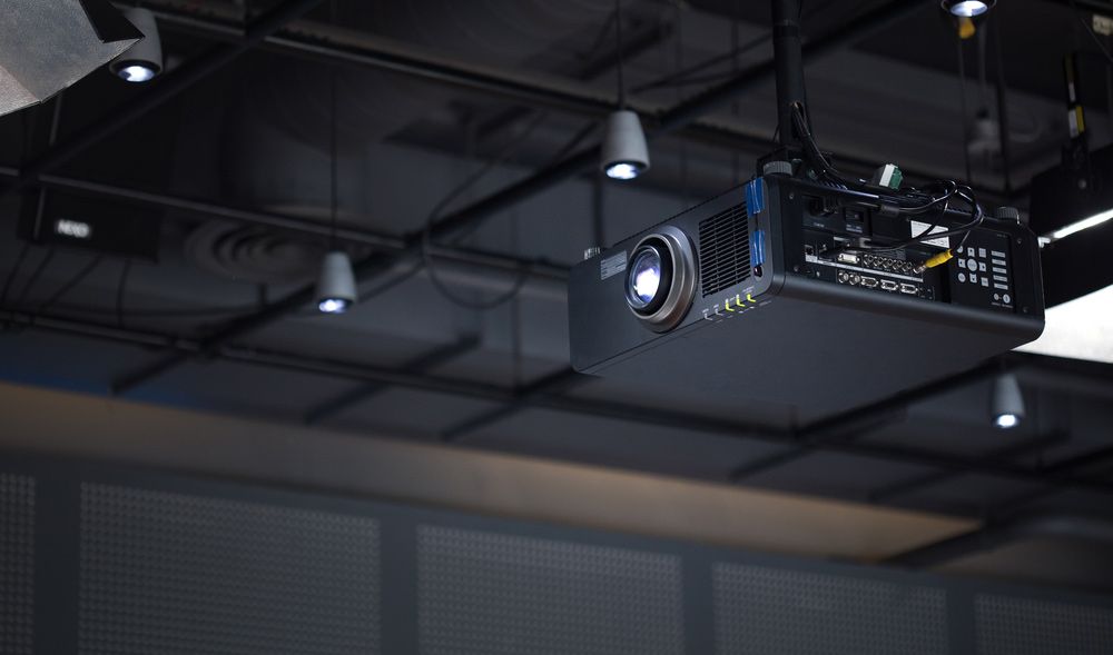 A Projector is Hanging From the Ceiling in a Dark Room — Atherton Electrical in Atherton, QLD