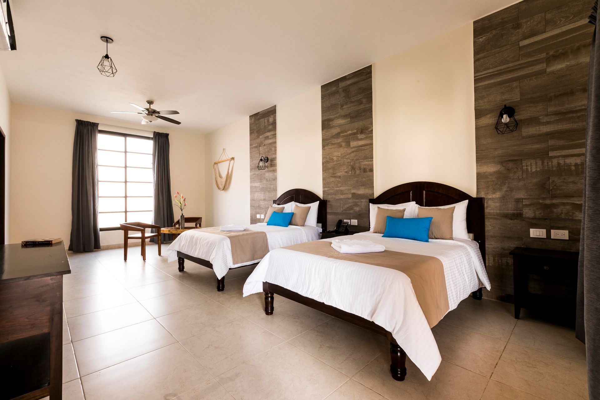A hotel room with two beds , a table and chairs.