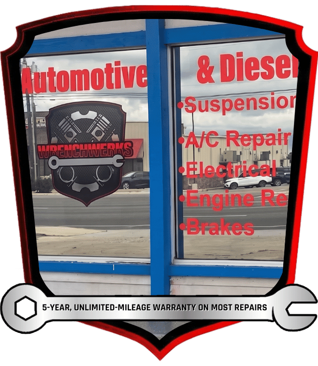 WrenchWerks shop window sign with red text, blue frame, and automotive service list.