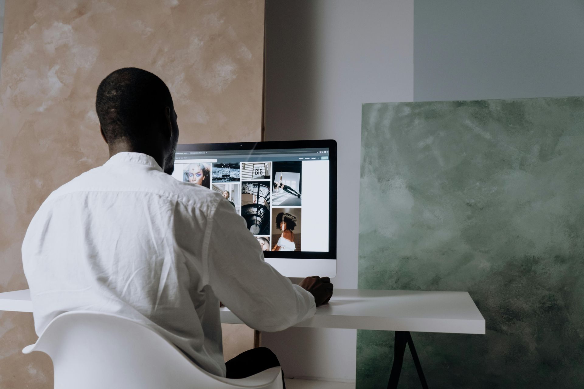 A man is sitting at a desk in front of a computer.