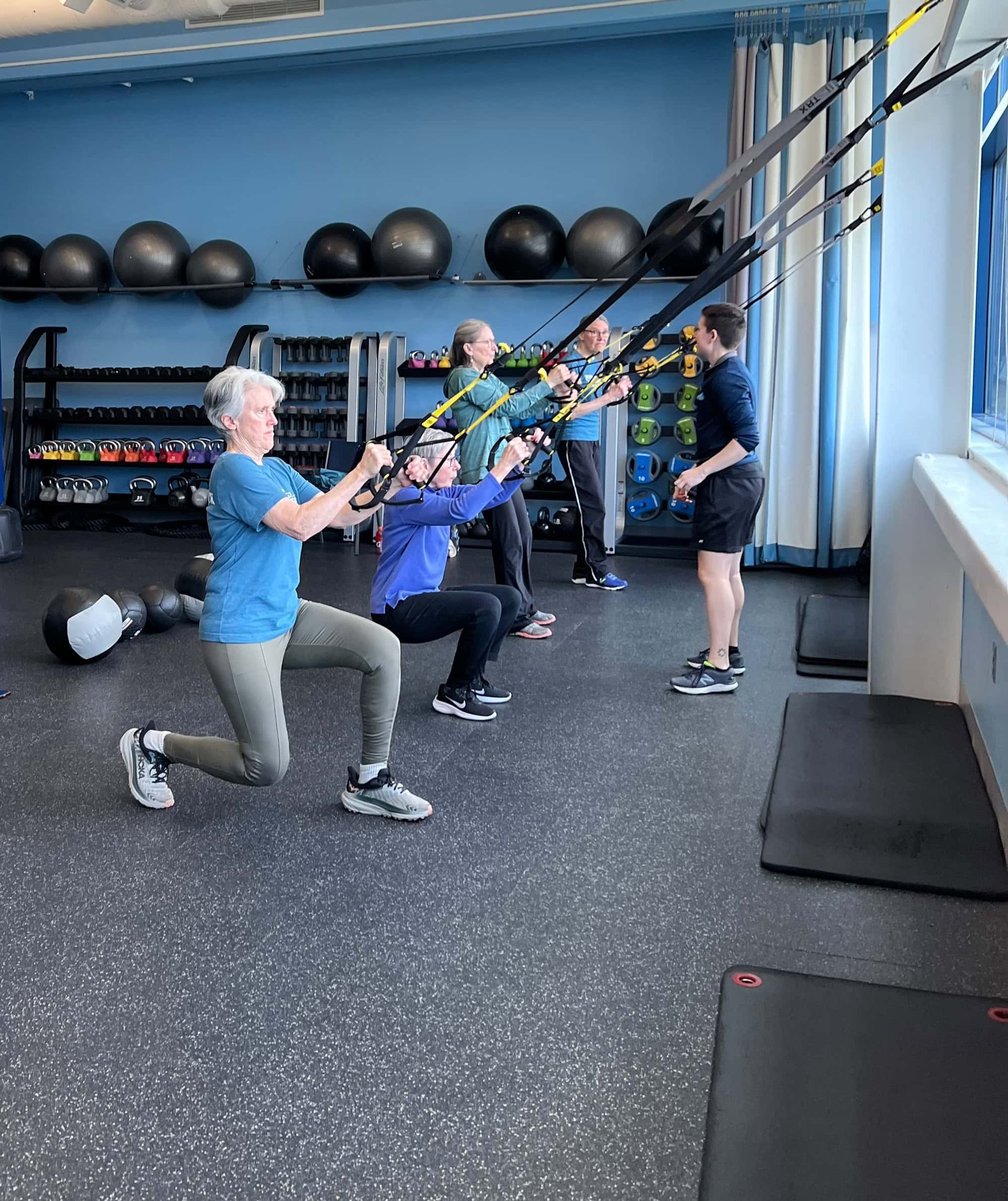 A group of people are doing exercises in a gym.