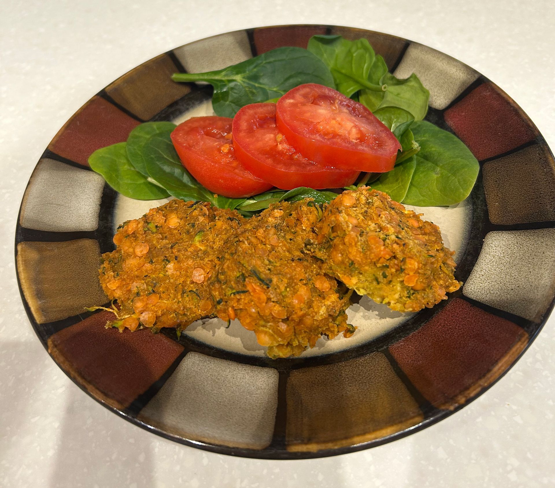 A plate of food with tomatoes and spinach on it