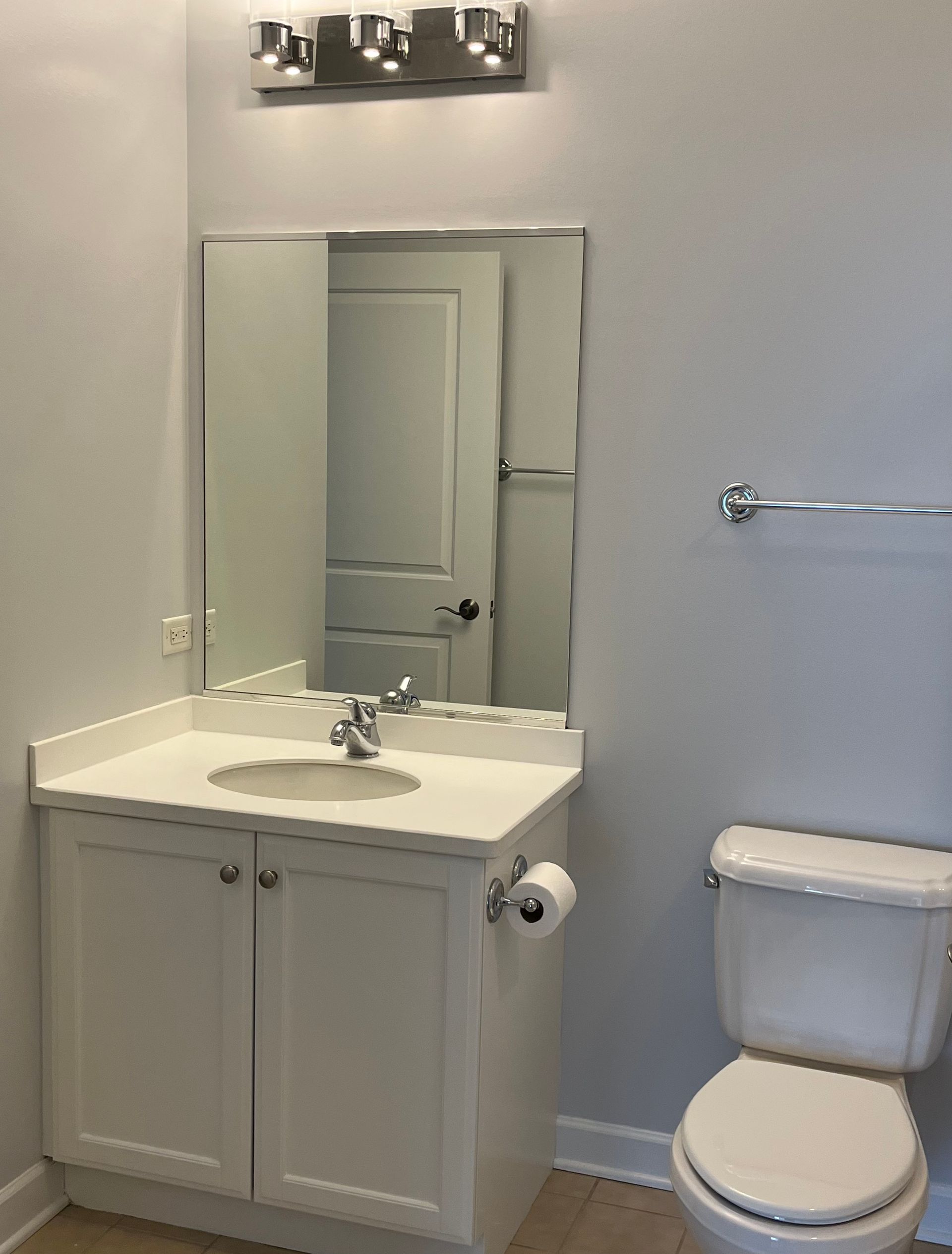 A bathroom with a toilet a sink and a mirror