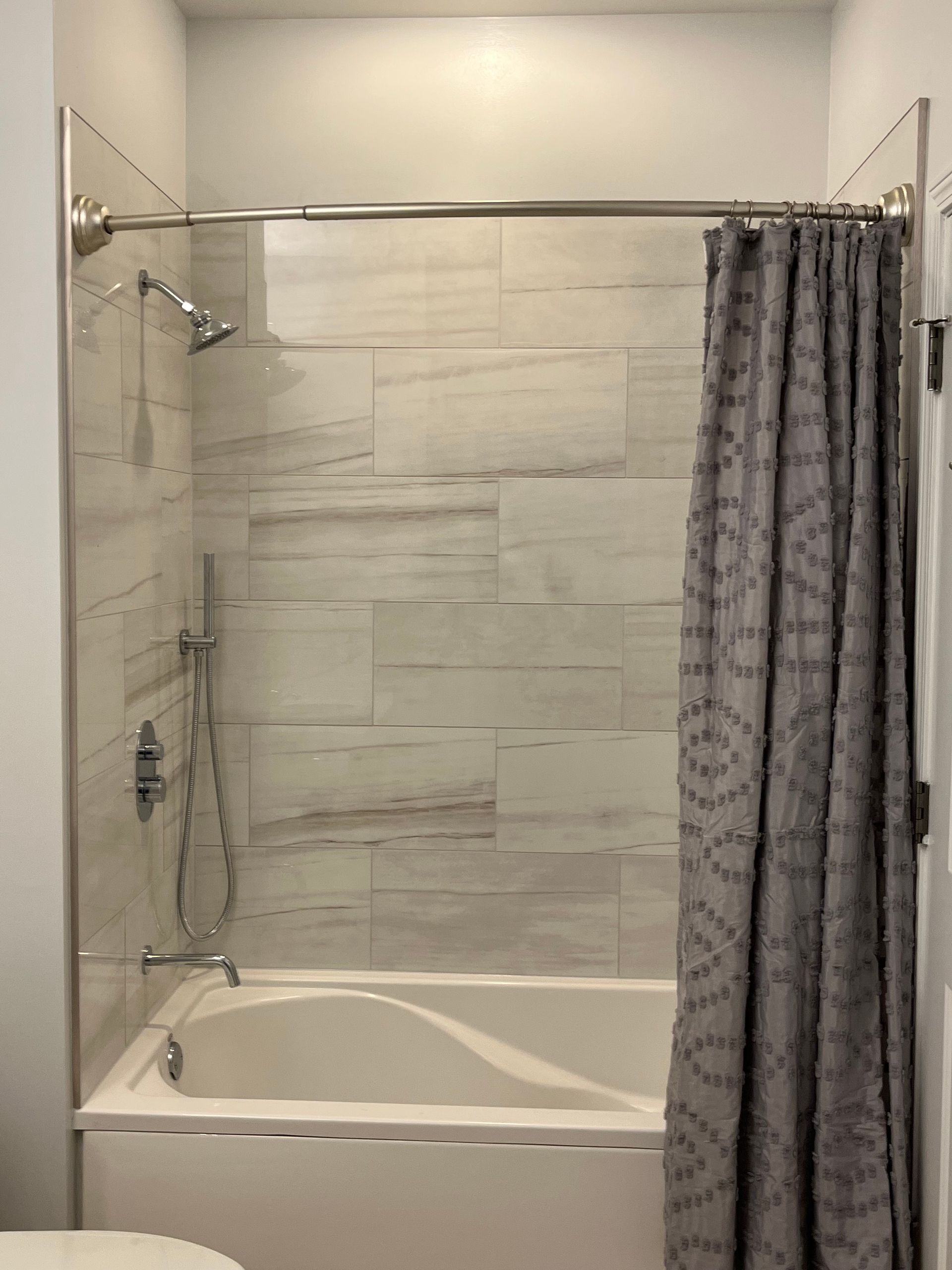 A bathroom with a bathtub and a shower curtain.