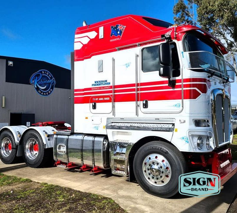 A Red and White Semi Truck is Parked in Front of a Building — Robinsons Sign Makers in Lavington, NSW