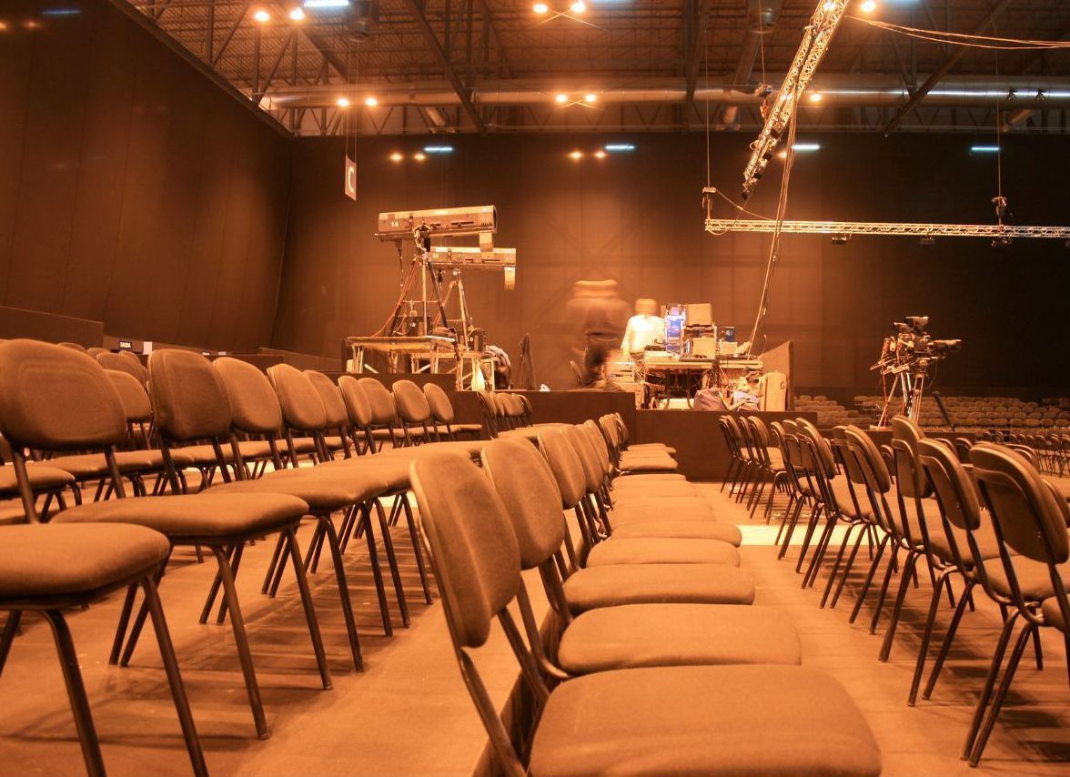 Rows of chairs in an auditorium with a stage in the background
