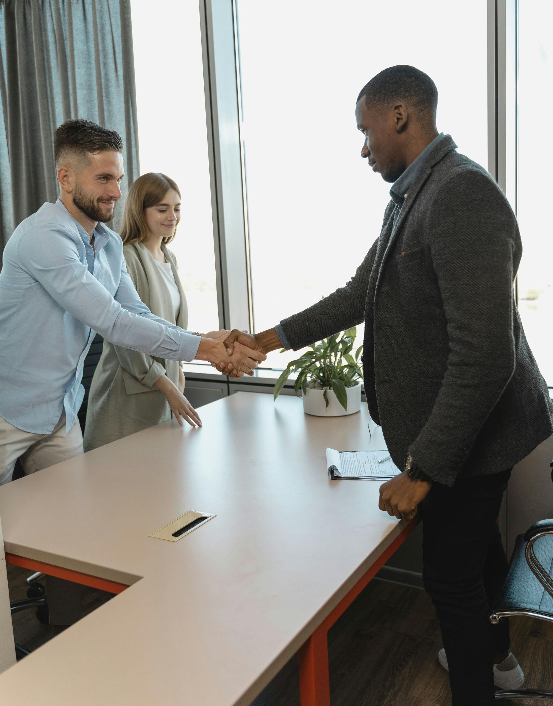 A man is shaking hands with another man in a conference room.