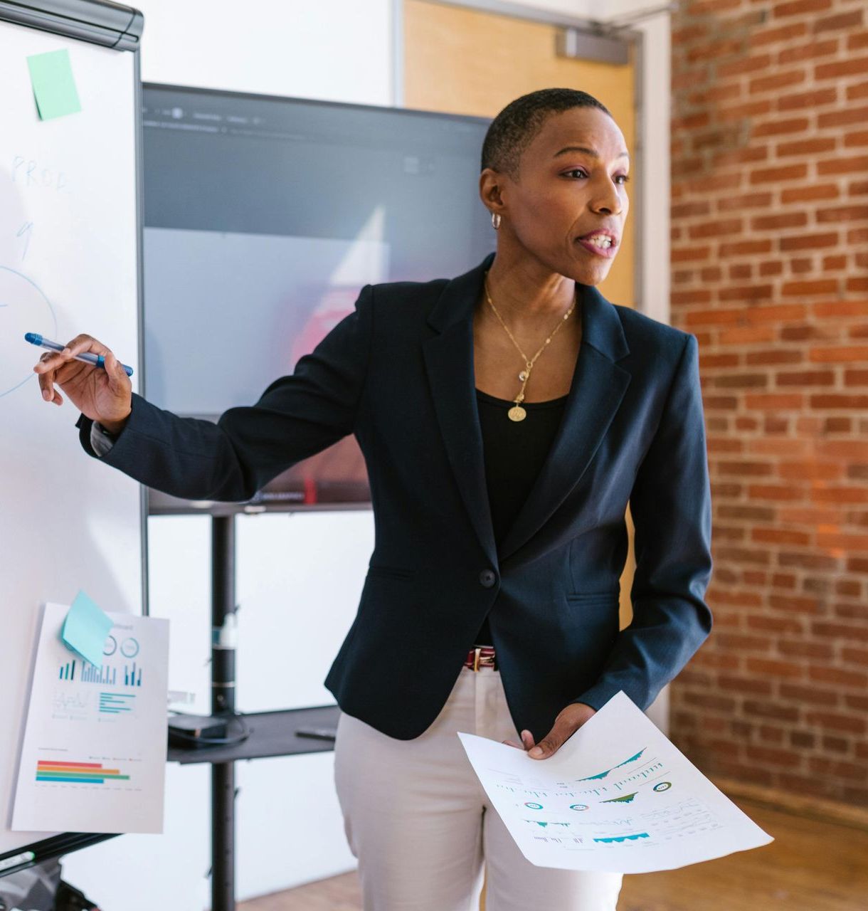 A woman in a black jacket is giving a presentation