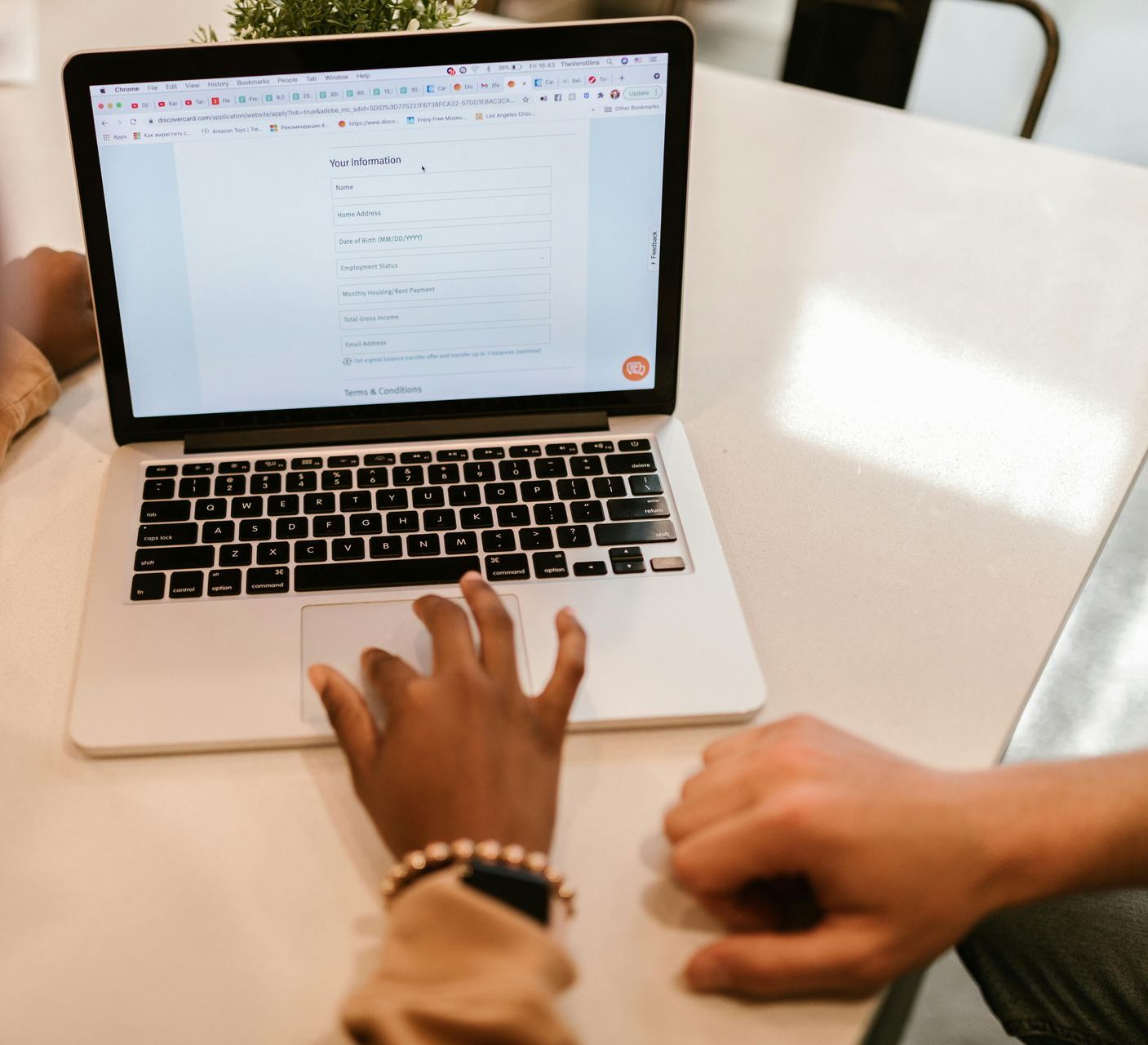 A person is typing on a laptop computer at a table