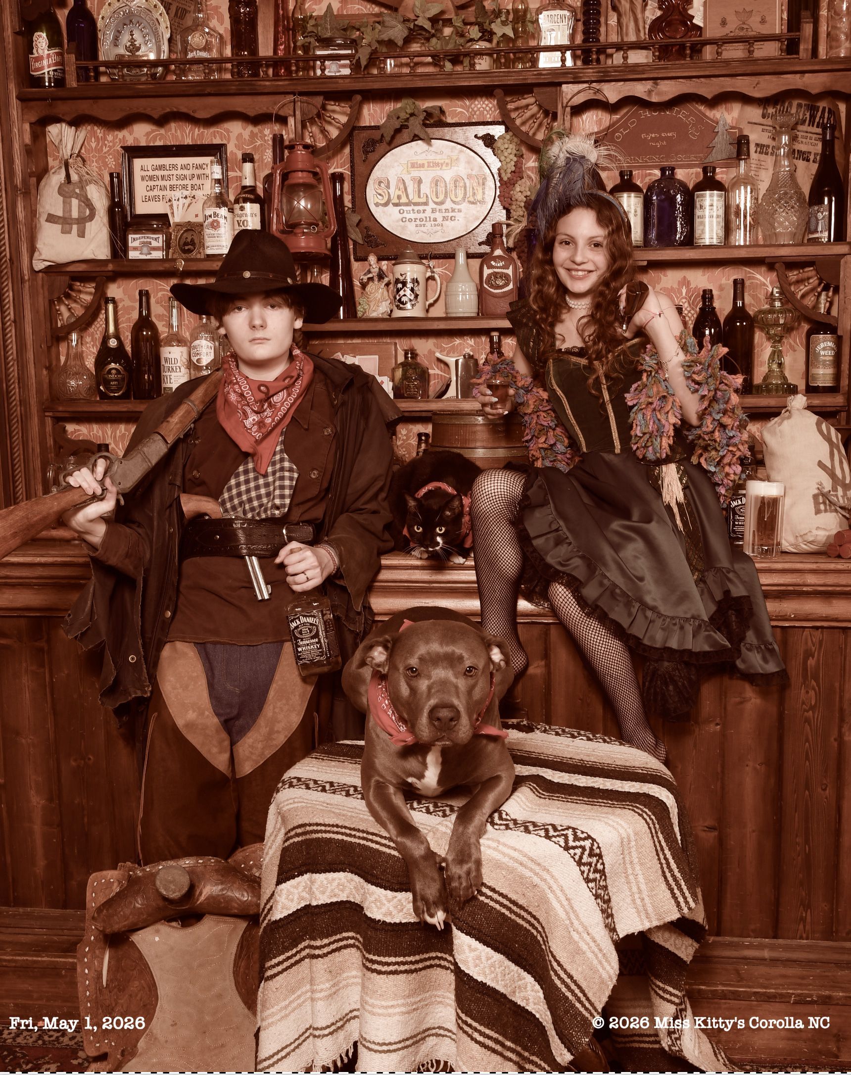 Sepia-toned western saloon scene with two young adults with a dog and a cat. Old Time Pet Photo with a dog in a hat and a cat, Miss Kitty's  Old Time Photos and Gifts 