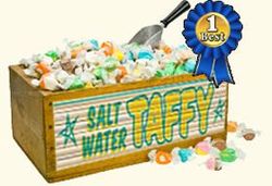 A wooden box filled with salt water taffy and a blue ribbon.