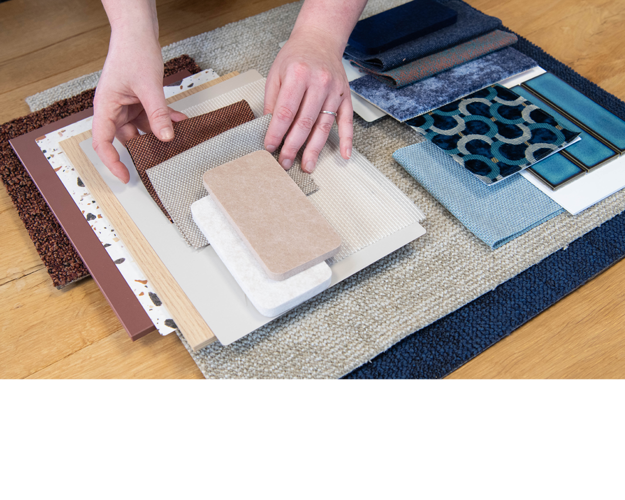 A man in a blue shirt is sanding a piece of wood