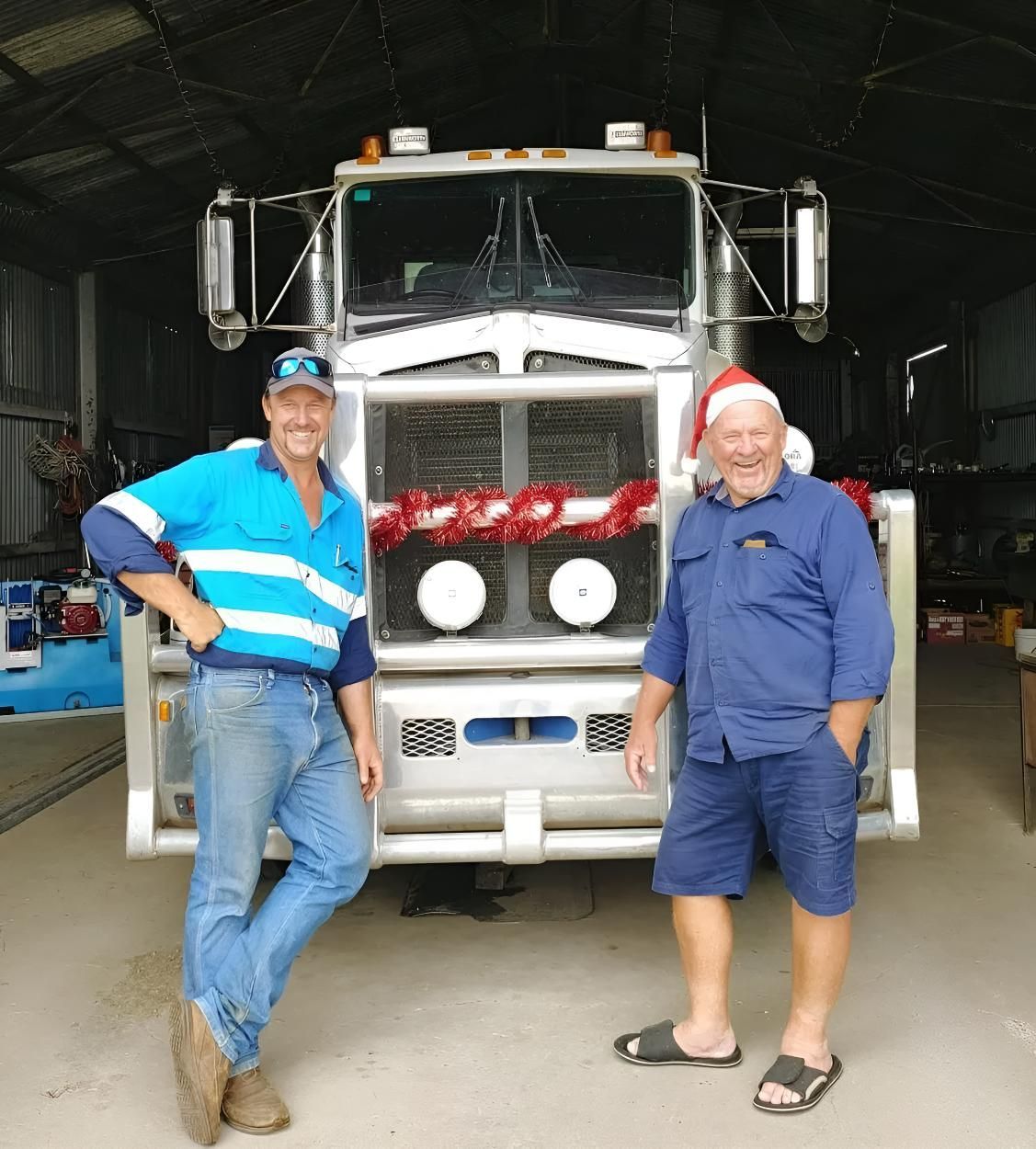 Two Men Wearing Santa Hats Are Standing in Front of a Truck — Wild Water Delivery in Bald Knob, QLD