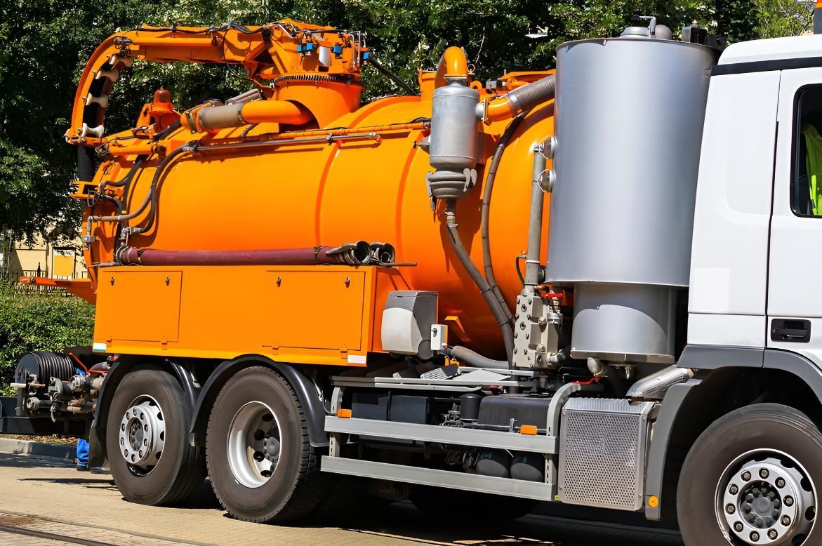 An Orange and White Vacuum Truck is Parked on the Side of the Road — Wild Water Delivery in Maleny, QLD