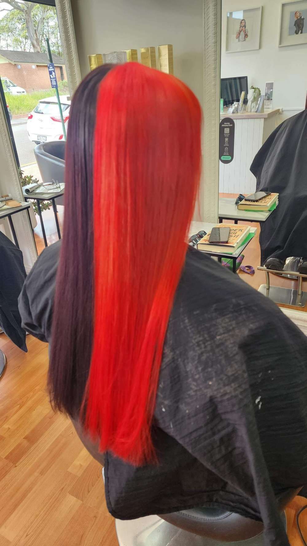 A Woman With Red and Purple Hair is Sitting in a Chair — Innovative Hair Salon in Gosford, NSW