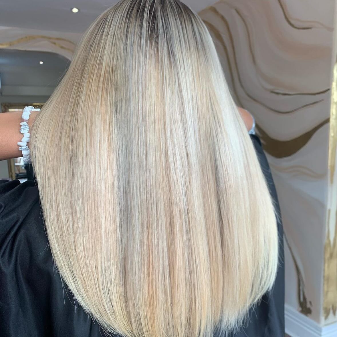A Woman With Long Blonde Hair Has a Bracelet on Her Wrist — Innovative Hair Salon in Gosford, NSW