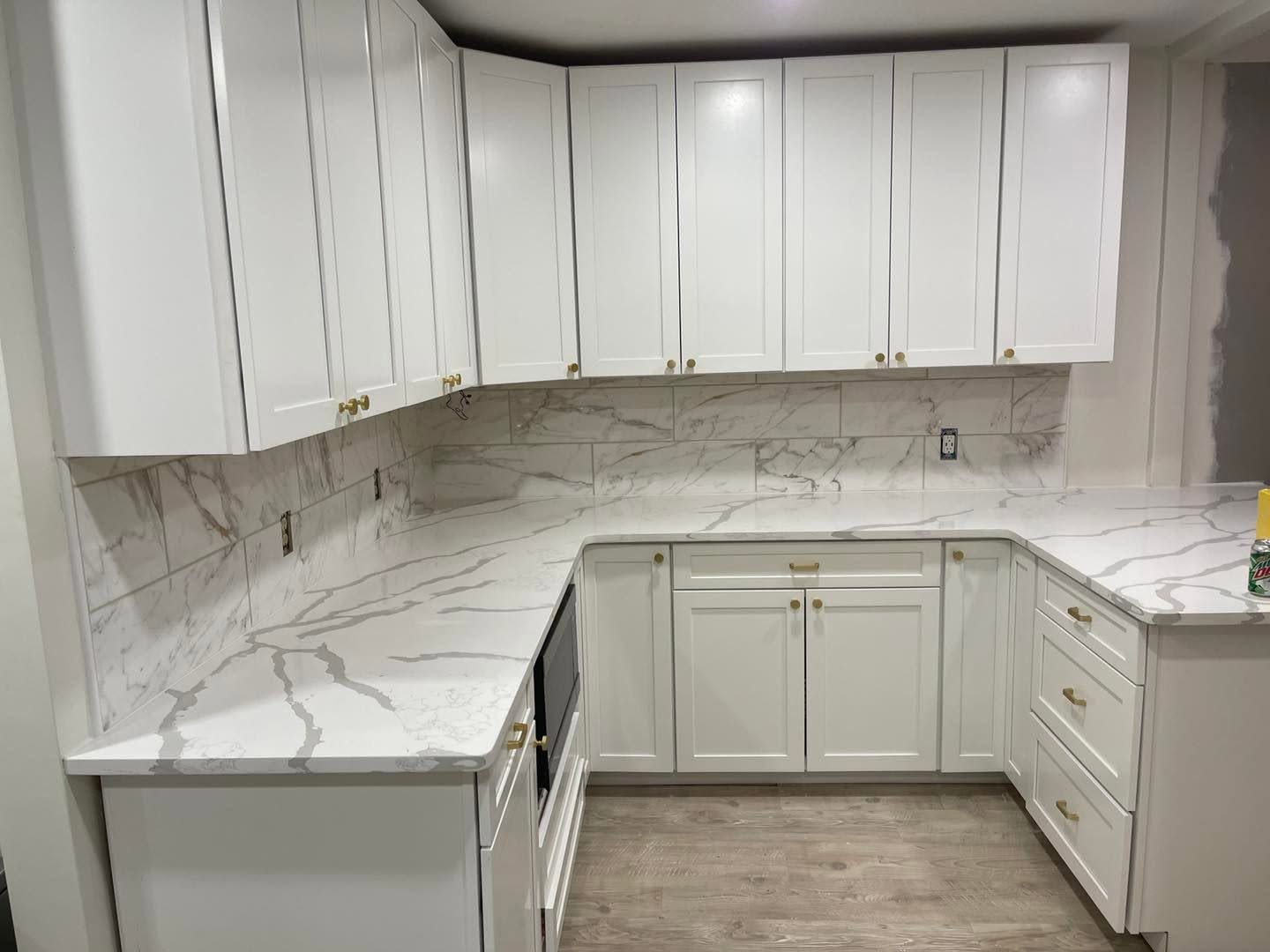 white kitchen cabinets with marble backsplash and counter