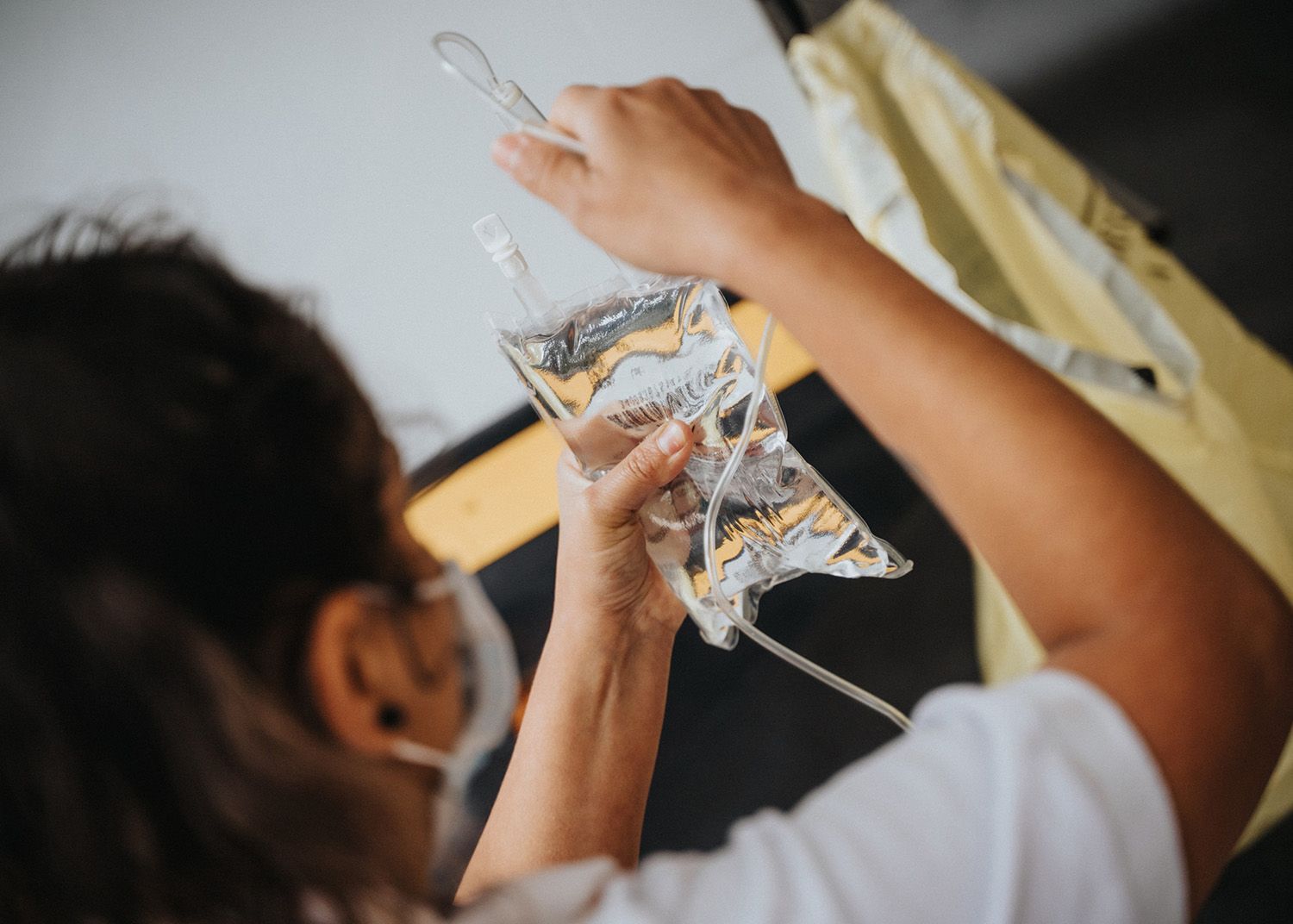 Person holding up a clear plastic pouch while working at a sink or lab station