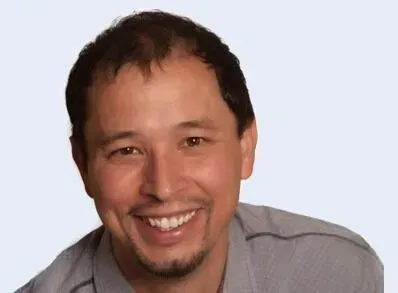 A man with a beard is smiling for the camera.