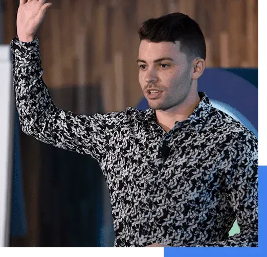 A man in a black and white shirt is giving a presentation.