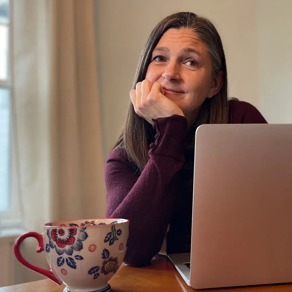 Andrea Tarka White with tea cup and computer