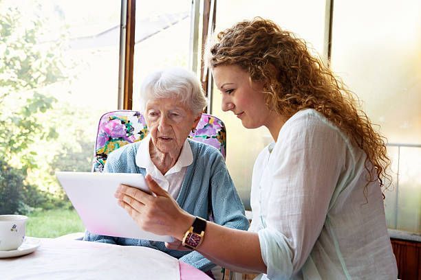 Woman Helping Elderly To Read - Branford, CT - Branford Hills Homecare Services 