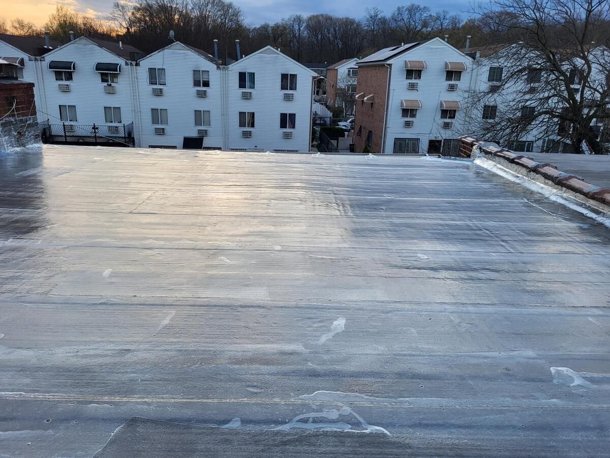 Snowy rooftop overlooking white apartment buildings at dusk
